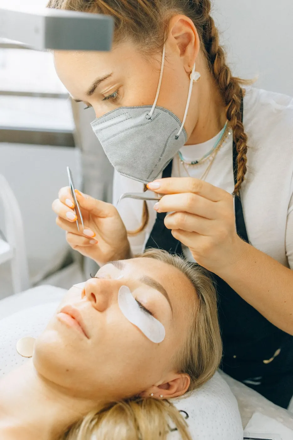 A lash technician working over a client