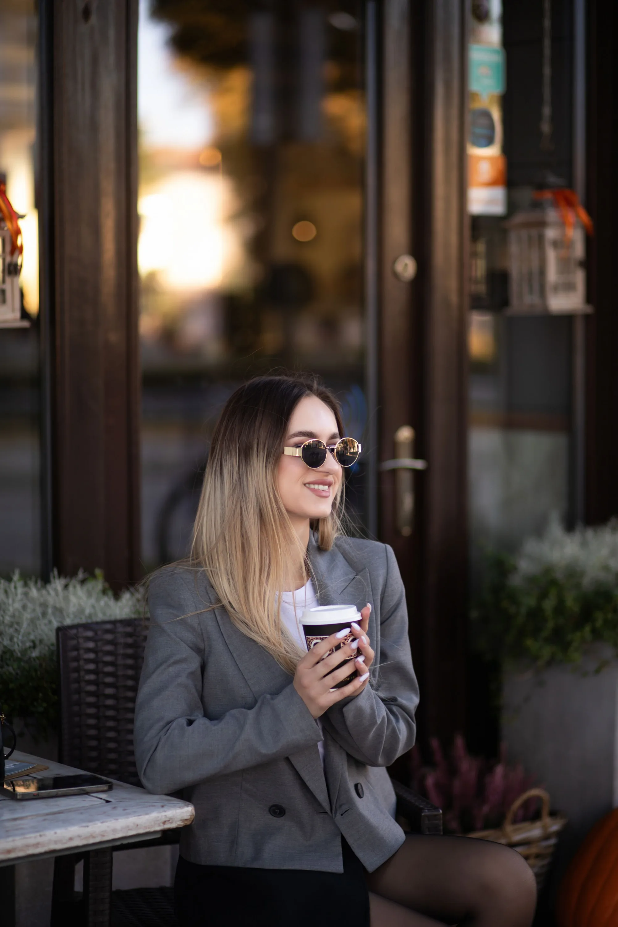 A woman with a coffee outside a cafe