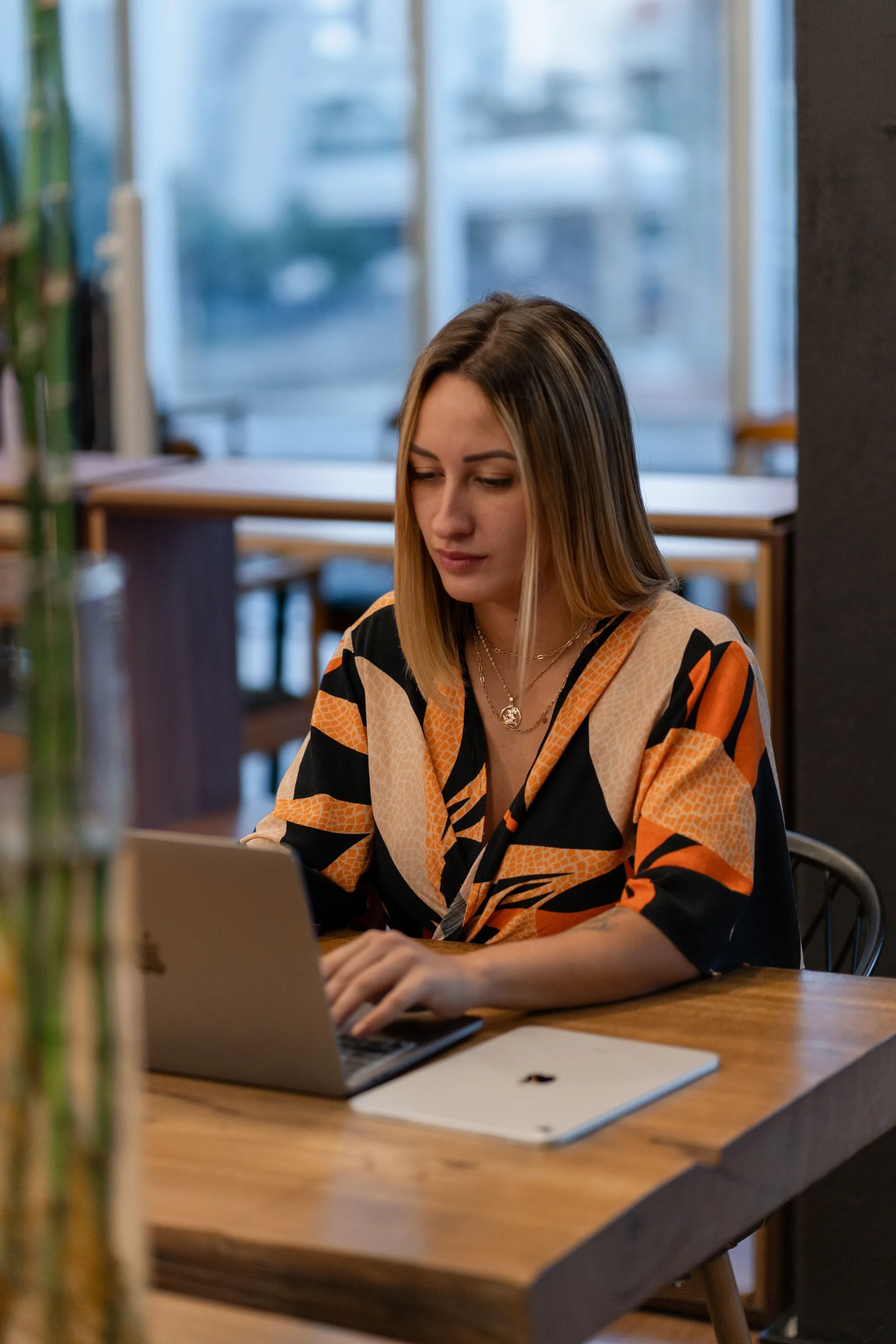 A studio owner working on a laptop at a café window