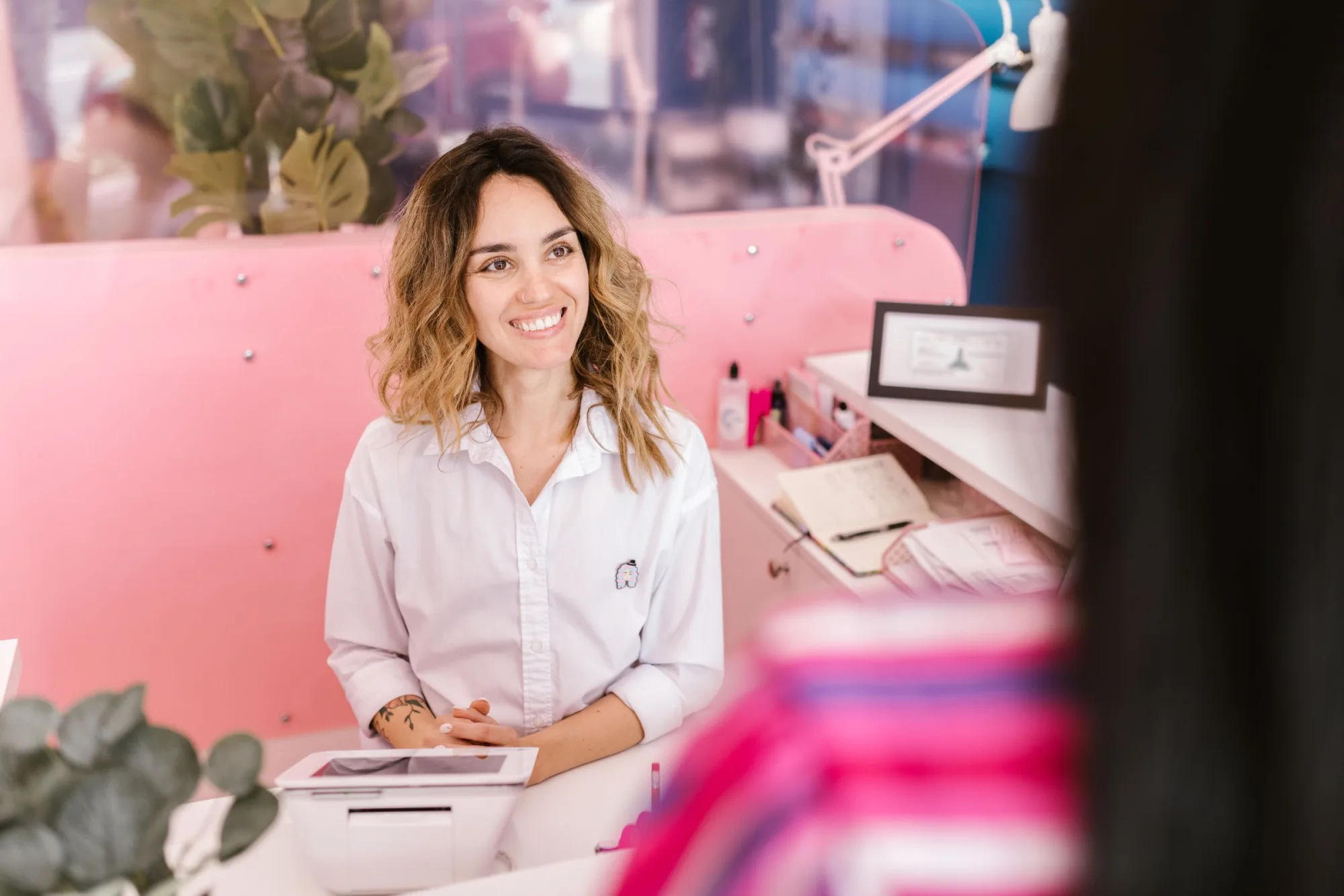 A salon owner smiling at her reception desk