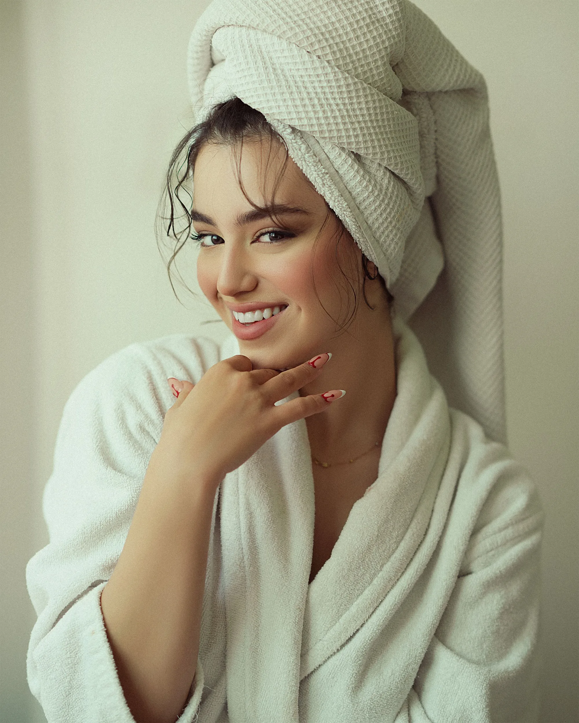 A client in a robe and towel, smiling