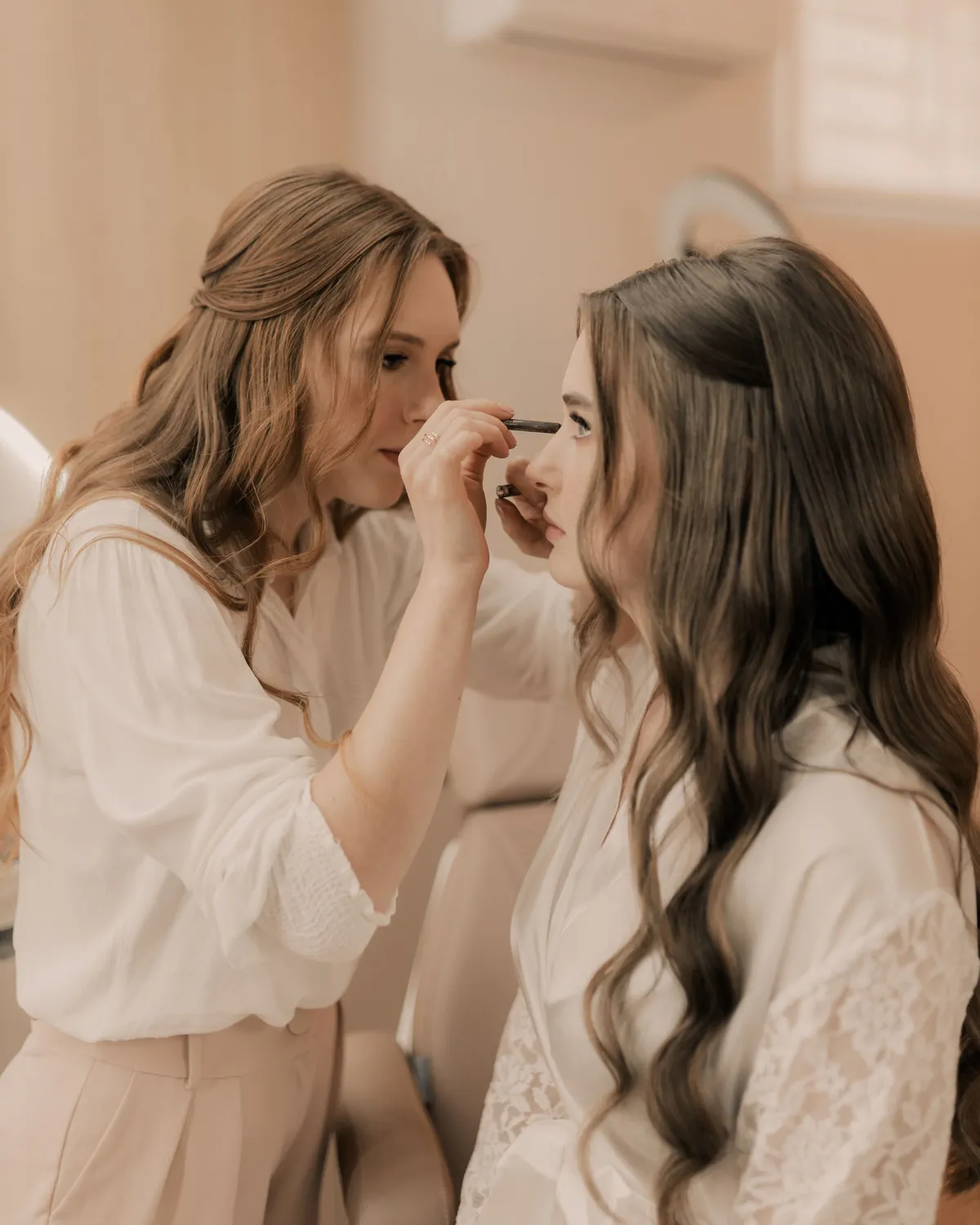 Makeup artist applying bridal makeup during a wedding preparation session